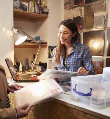Female customer being served at the counter of a record shop Female customer being served at the counter of a record shop
